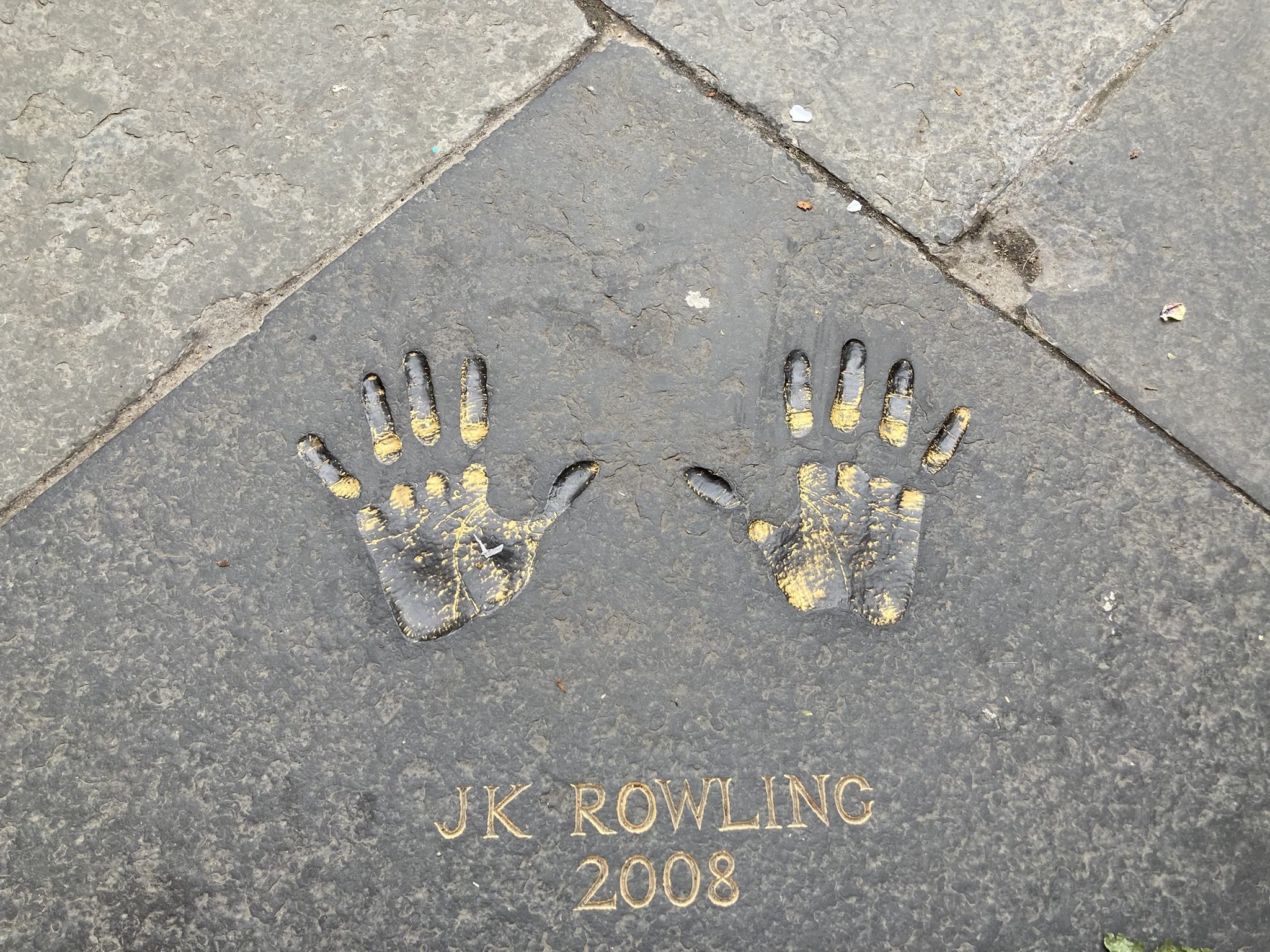 De handafdrukken van J.K. Rowling op een stoeptegel met het jaartal 2008 eronder.