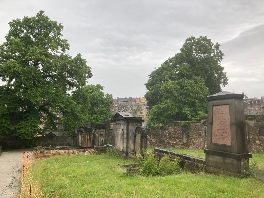 Kerkhof Blackfriars Kirkyard in Edinburgh, met zwarte graven op een groen stukje gras.